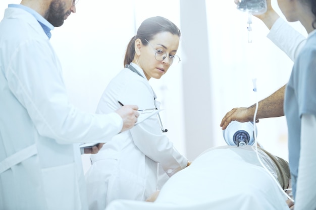 Grupo de médicos uniformizados trabalhando na sala de reanimação do hospital