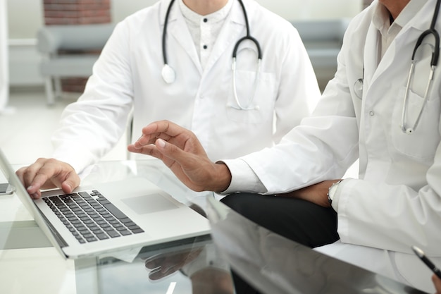 grupo de médicos usando um laptop em uma reunião de trabalho.