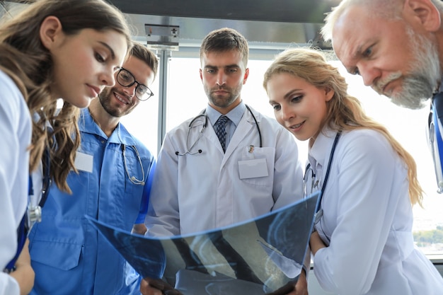 Foto grupo de médicos verificando raios-x em um hospital.