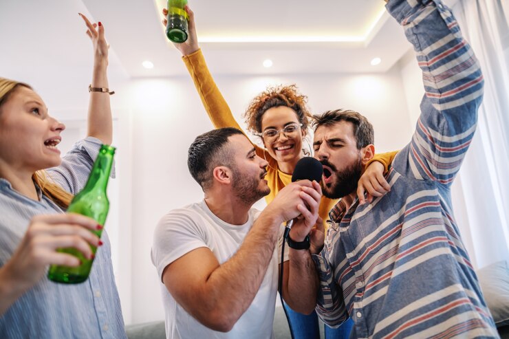 Foto grupo de melhores amigas se divertindo em casa. eles estão bebendo cerveja e tendo uma noite de karaokê.