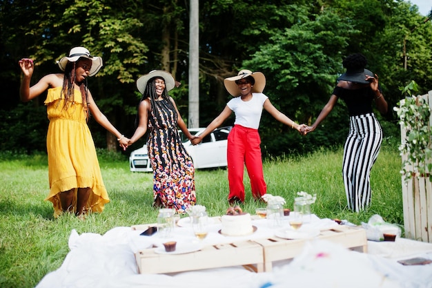 Grupo de meninas afro-americanas comemorando festa de aniversário se divertindo e dançando ao ar livre com decoração.