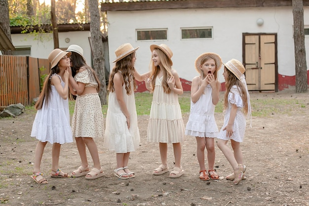 Foto grupo de meninas pré-adolescentes emocionais odiando no pátio da propriedade rural