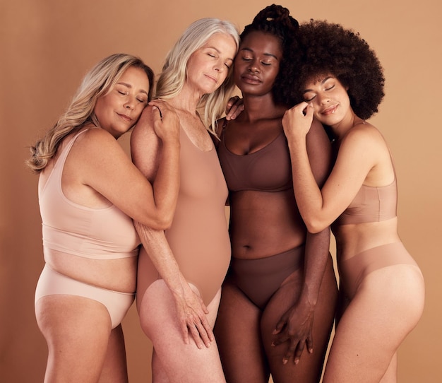 Grupo de modelos de mulheres plus size e lingerie em estúdio para apoio, solidariedade e diversidade com conforto Mulher multicultural positiva corporal e roupas íntimas com abraço, amor e juntas pelo cenário do estúdio