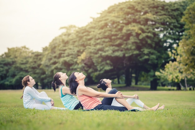 Grupo de mulher yoga exercício ao ar livre em uma manhã brilhante do parque