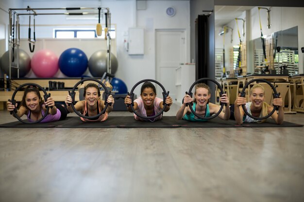 Grupo de mulheres em forma se exercitando com anel de pilates