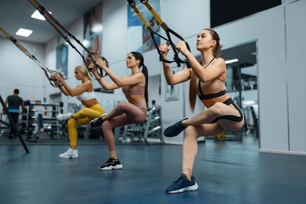Grupo de mulheres fazendo exercícios de equilíbrio no ginásio.