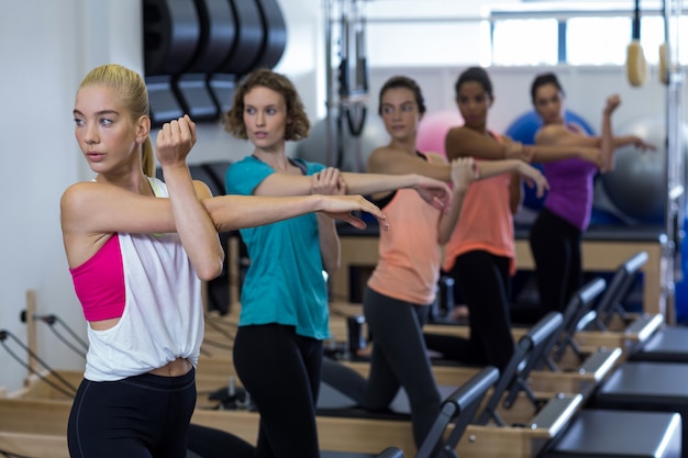 Foto grupo de mulheres fazendo exercícios no reformador