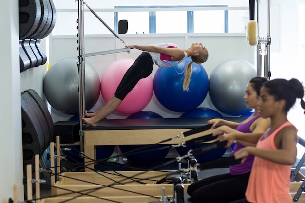 Grupo de mulheres fazendo exercícios no reformador