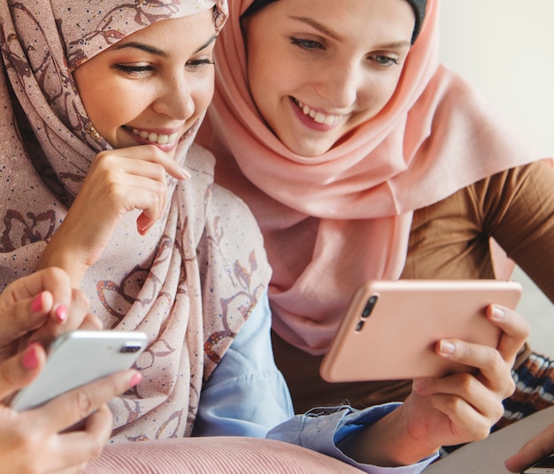 Grupo de mulheres islâmicas conversando e assistindo ao telefone juntos