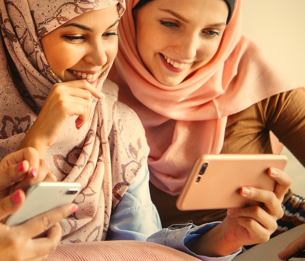 Grupo de mulheres muçulmanas jogando em smartphones