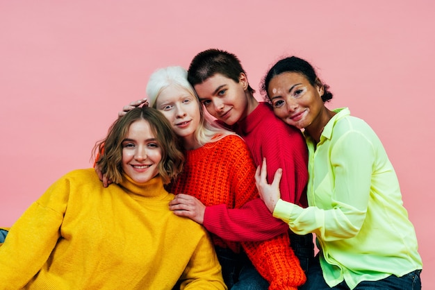 Grupo de mulheres multiétnicas com diferentes tipos de pele posando juntas em estúdio