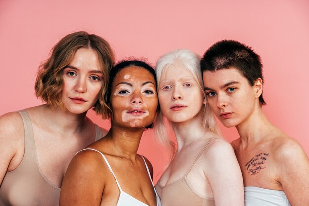 grupo de mulheres multiétnicas com diferentes tipos de pele posando juntas em estúdio