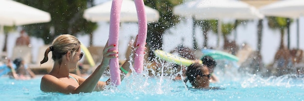 Grupo de mulheres na piscina fazendo estilo de vida saudável de hidroginástica e conceito de esporte