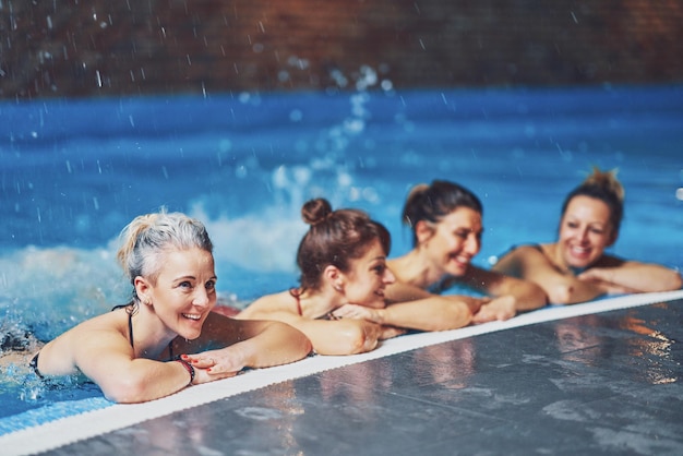 Grupo de mulheres na piscina tendo treinamento