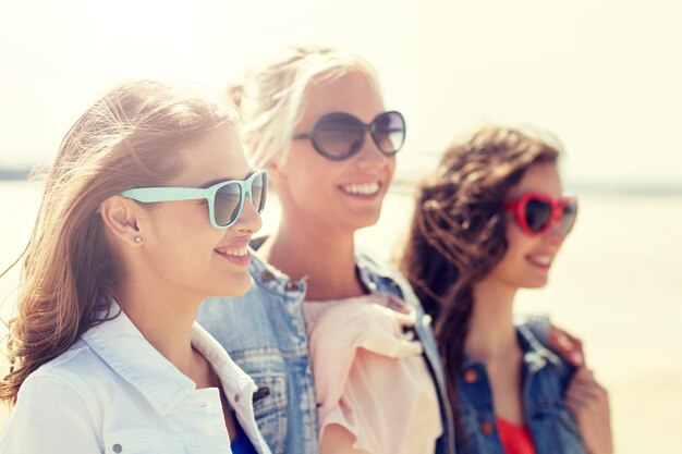 Foto grupo de mulheres sorrindo em óculos de sol na praia