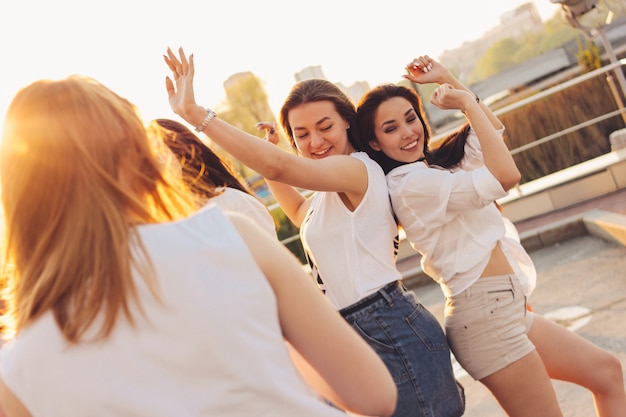 Grupo de namoradas despreocupadas lindas dançando se divertir na rua da cidade