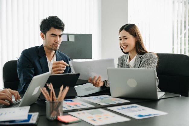 Grupo de negócios asiáticos se reúnem em planejamento de design em negócios criativos discutindo o trabalho no escritório moderno