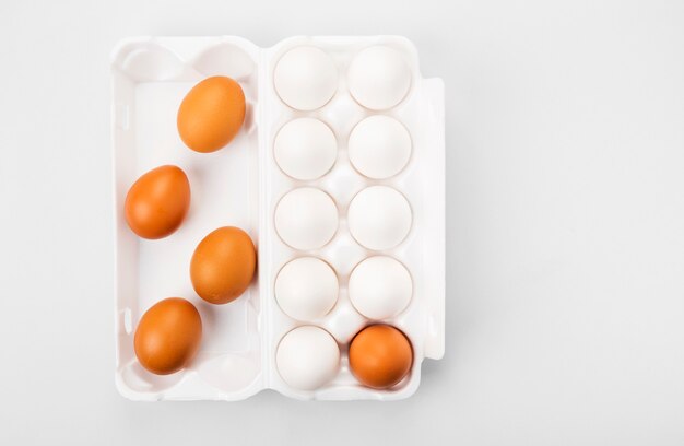 Grupo de ovos crus brancos e marrons.