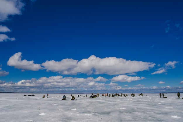 Grupo de pescadores que pescam no lago de gelo