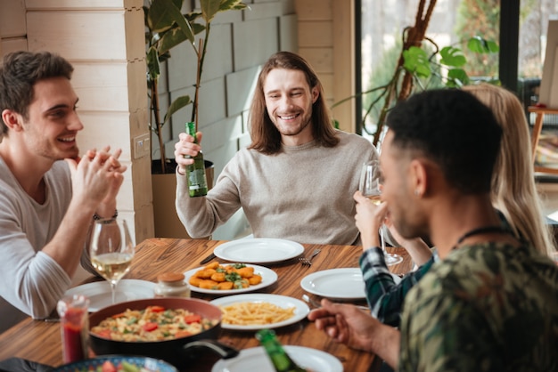 Grupo de pessoas bebendo cerveja e vinho no jantar