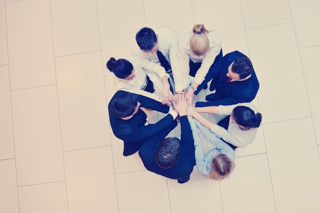 grupo de pessoas de negócios juntando as mãos e permanecendo como equipe em círculo e representando o conceito de amizade e trabalho em equipe