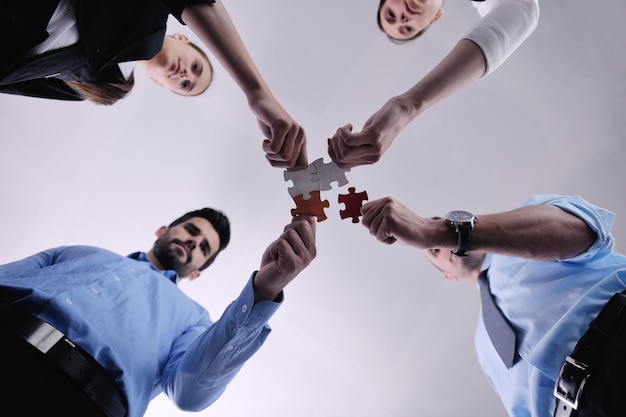 Foto grupo de pessoas de negócios montando quebra-cabeças e representam o apoio da equipe e o conceito de ajuda