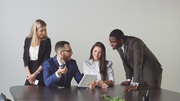 Grupo de pessoas de negócios que usam computador tablet durante uma reunião.