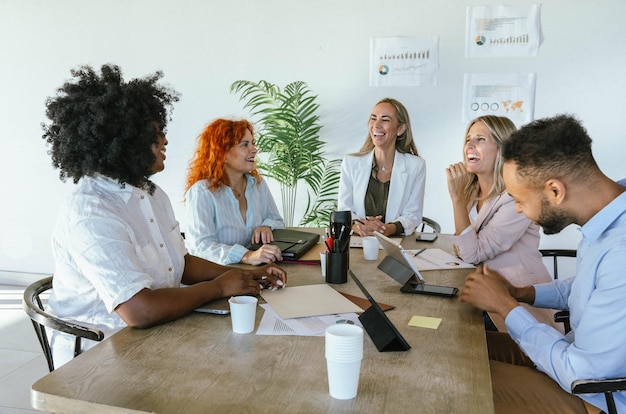 Foto grupo de pessoas de negócios sorrindo enquanto têm uma reunião de trabalho no escritório