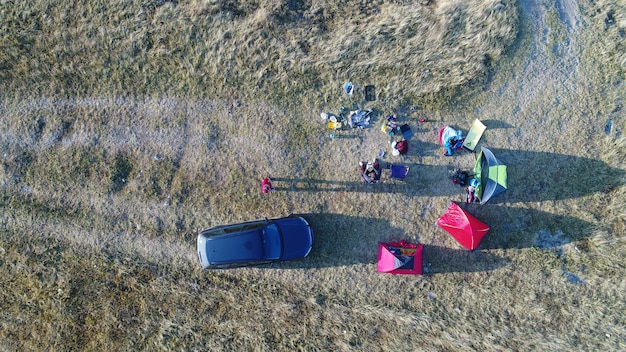 Grupo de pessoas desfrutando de acampamento de tenda nas montanhas vista aérea carro não reconhecível