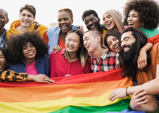 Grupo de pessoas diversas felizes se divertindo ao ar livre com a bandeira LGBT rianbow - Foco na garota careca