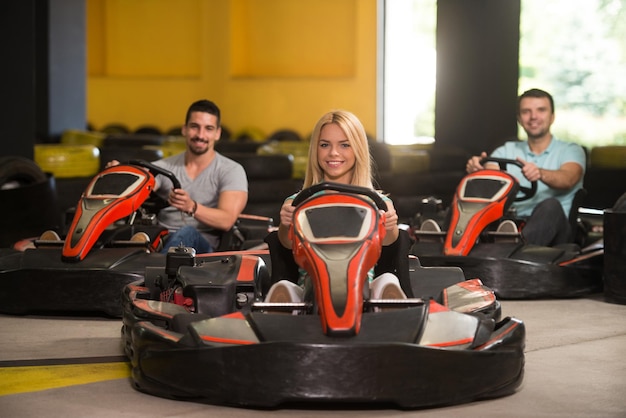Grupo de pessoas está dirigindo o carro GoKart com velocidade em uma pista de corrida de playground Go Kart é um esporte motorizado de lazer popular