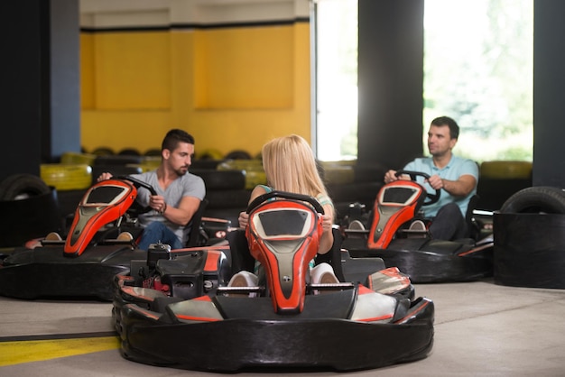 Grupo de pessoas está dirigindo o carro GoKart com velocidade em uma pista de corrida de playground Go Kart é um esporte motorizado de lazer popular