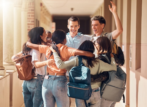 Grupo de pessoas, estudantes felizes e abraços para a celebração da educação, apoio inter-racial ou sucesso do projeto de estudo Diversidade, amigos da universidade celebram e abraçam a felicidade no corredor da construção