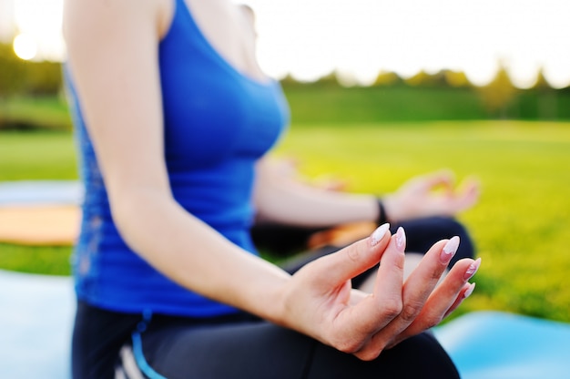 Grupo de pessoas fazendo yoga no campo verde