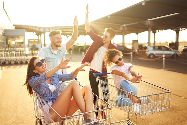 Grupo de pessoas felizes se divertindo em carrinhos de compras Pessoas multiétnicas correndo no carrinho de compras