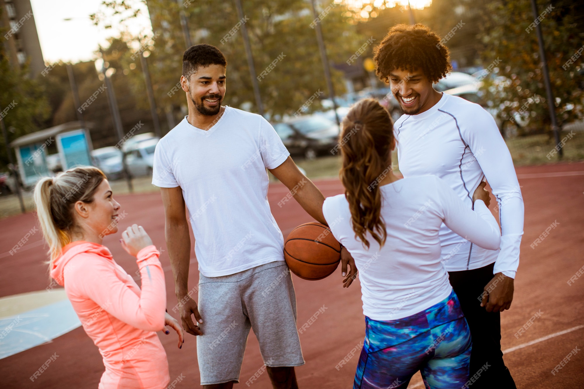 Grupo de pessoas multiétnicas jogando basquete na quadra