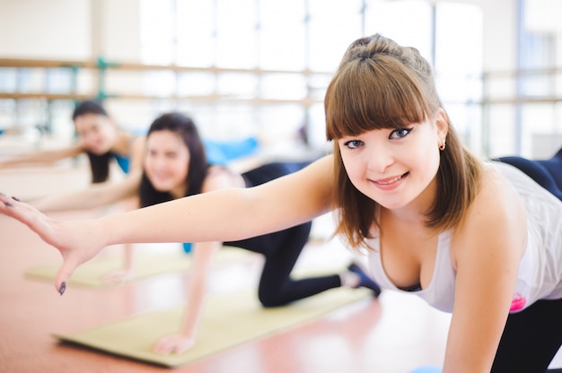 Grupo de pessoas na academia em uma aula de alongamento