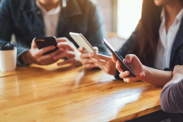 Grupo de pessoas usando e olhando para o telefone celular sentadas juntas