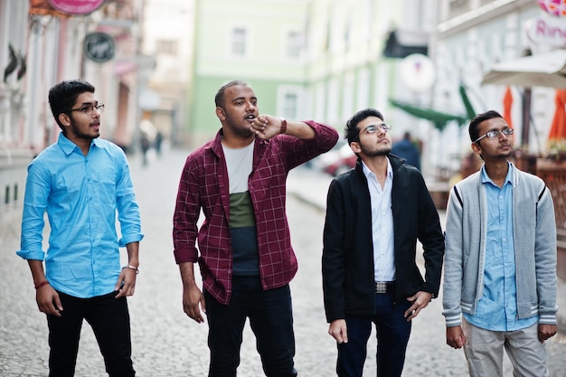 Grupo de quatro estudantes indianos do sexo masculino adolescentes. Os colegas passam tempo juntos.