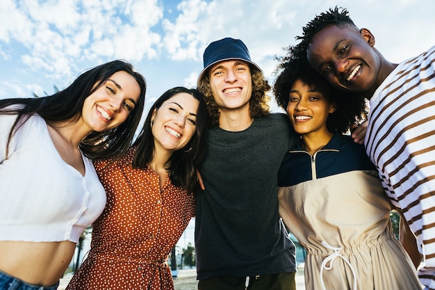 Grupo de retratos de jovens multirraciais felizes em pé ao ar livre em um dia ensolarado