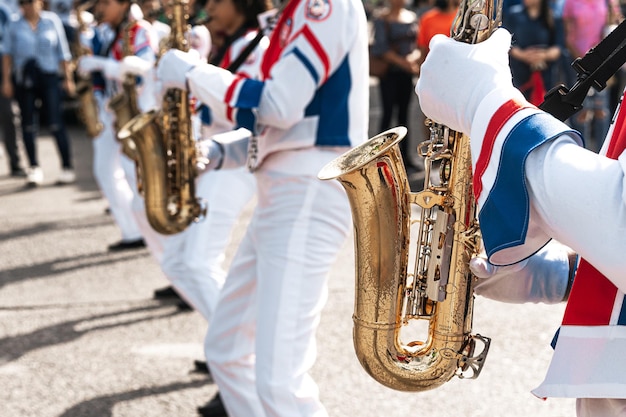 Grupo de saxofonistas tocando saxofone em uma marcha patriótica