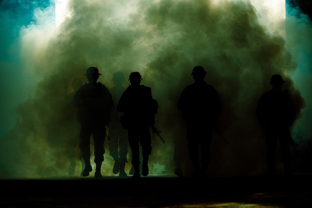Grupo de silhueta de soldados tailandeses forças especiais equipe completa em uniforme caminhando ação através da fumaça