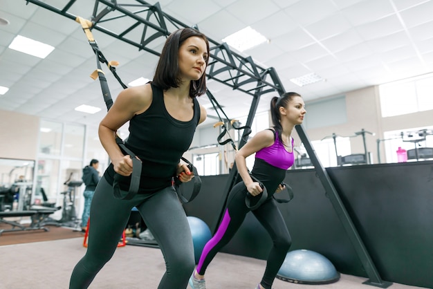 Grupo de treinamento com laços de fitness no ginásio