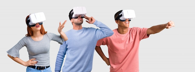 Foto grupo de três amigos usando óculos vr. experiência de realidade virtual