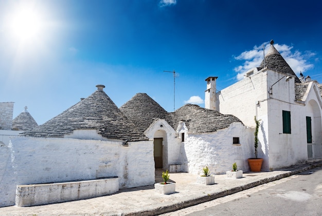 Grupo de Trulli com símbolos, casas antigas tradicionais e antigo muro de pedra em Puglia, Itália