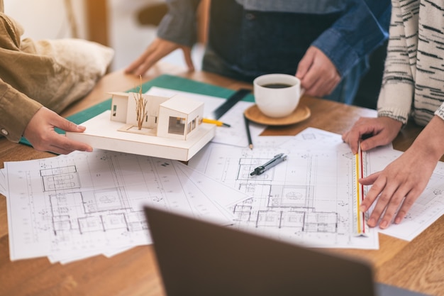 Foto grupo de um arquiteto trabalhando e medindo a escala de um modelo de massa na mesa do escritório