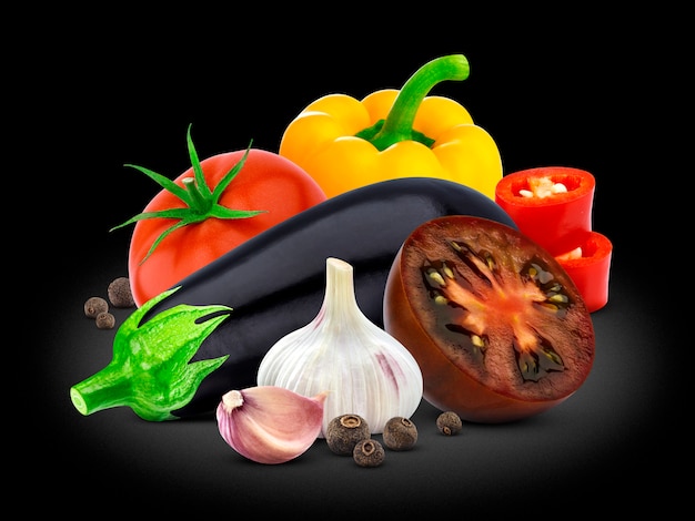 Grupo de vegetais, berinjela, tomate, pimenta e alho no preto.