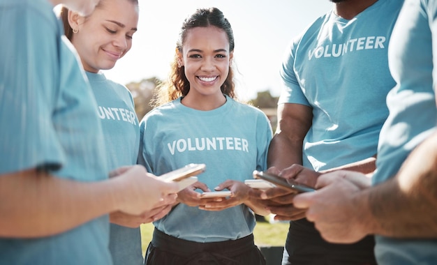 Foto grupo de voluntários e retrato de mulher com telefone para blog, bate-papo on-line e atualização de site de caridade, trabalho em equipe de serviço comunitário e feliz em smartphone ao ar livre para limpeza ou reciclagem nas redes sociais