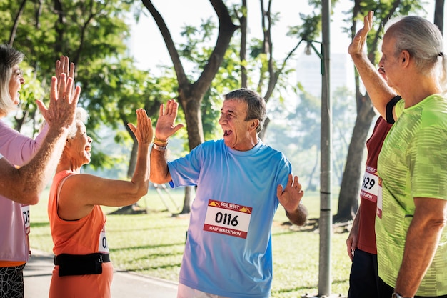 Grupo de deportistas senior dando un máximo de cinco.