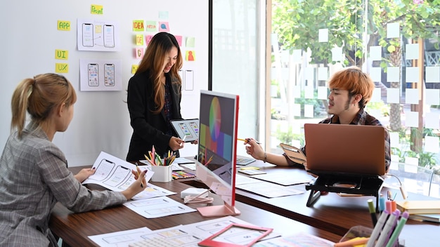 El grupo de desarrolladores web está haciendo una lluvia de ideas y planificando juntos el diseño del marco del prototipo del boceto del futuro proyecto de diseño de la aplicación